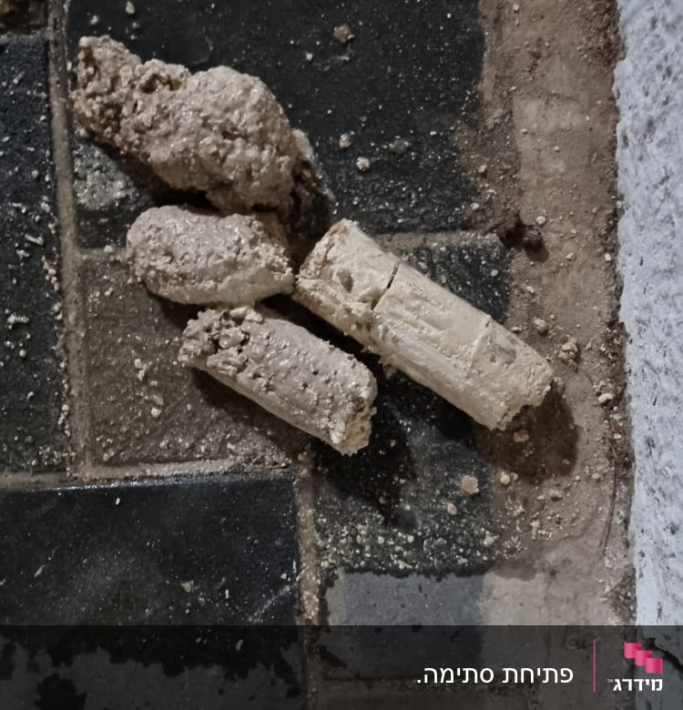 חלקי בטון שבורים על רצפה כהה